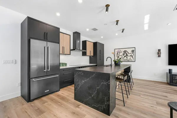 a kitchen with stainless steel appliances granite countertop a kitchen island a stove a cabinets a sink and a chairs
