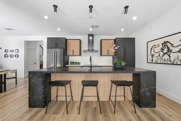 a living room with furniture a wooden floor and kitchen view