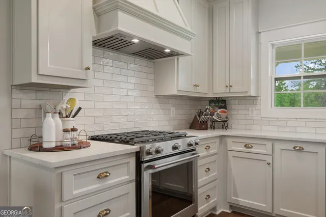 a kitchen with white cabinets and appliances
