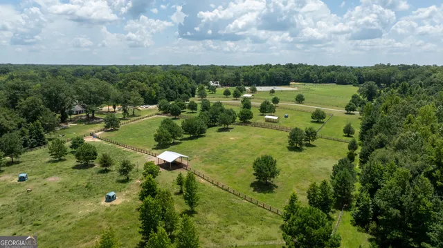 an aerial view of a house with a lush green forest