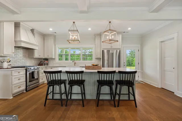 a dining room with wooden floor a chandelier a wooden table and chairs