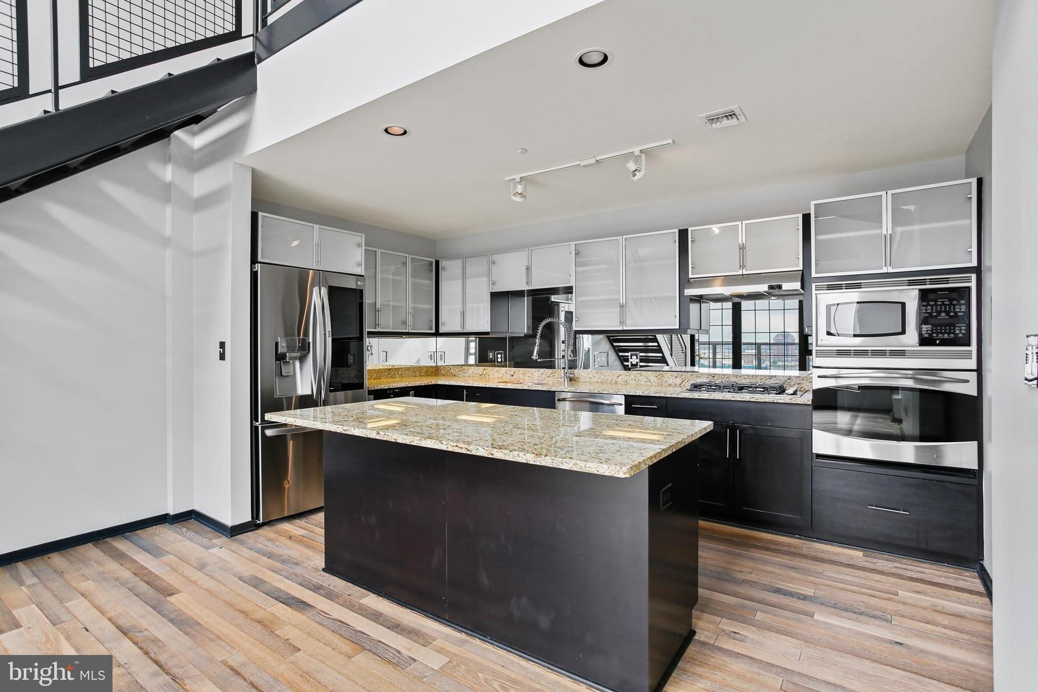 1200 Steuart Street, Unit 1913 Baltimore, MD 21230 - Photo 12 of 39 a kitchen with stainless steel appliances granite countertop a sink stove and refrigerator