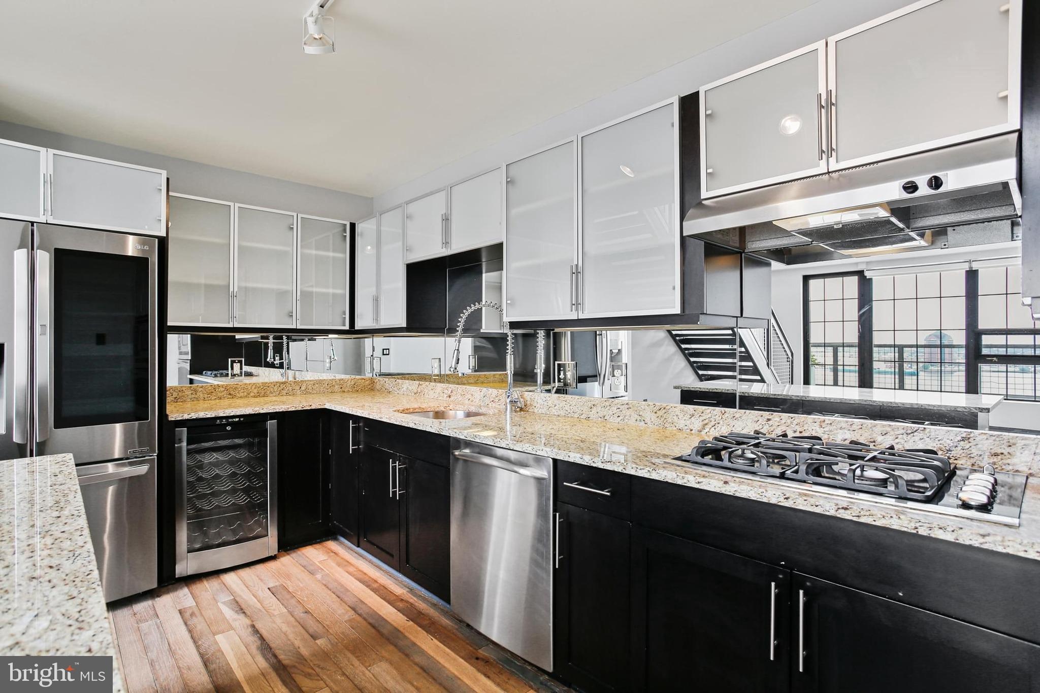 1200 Steuart Street, Unit 1913 Baltimore, MD 21230 - Photo 15 of 39 a kitchen with stainless steel appliances kitchen island granite countertop a sink stove and refrigerator