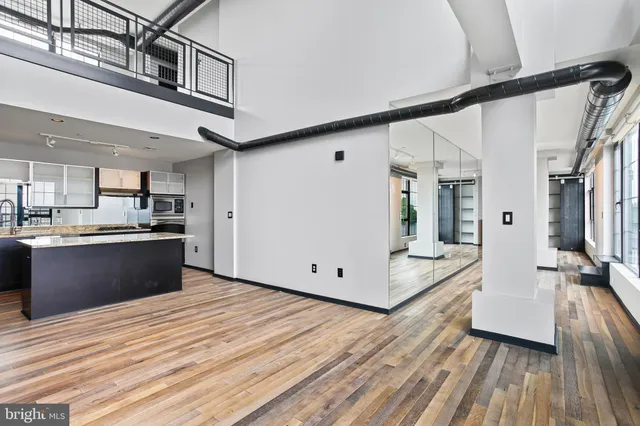 a large white kitchen with wooden floor