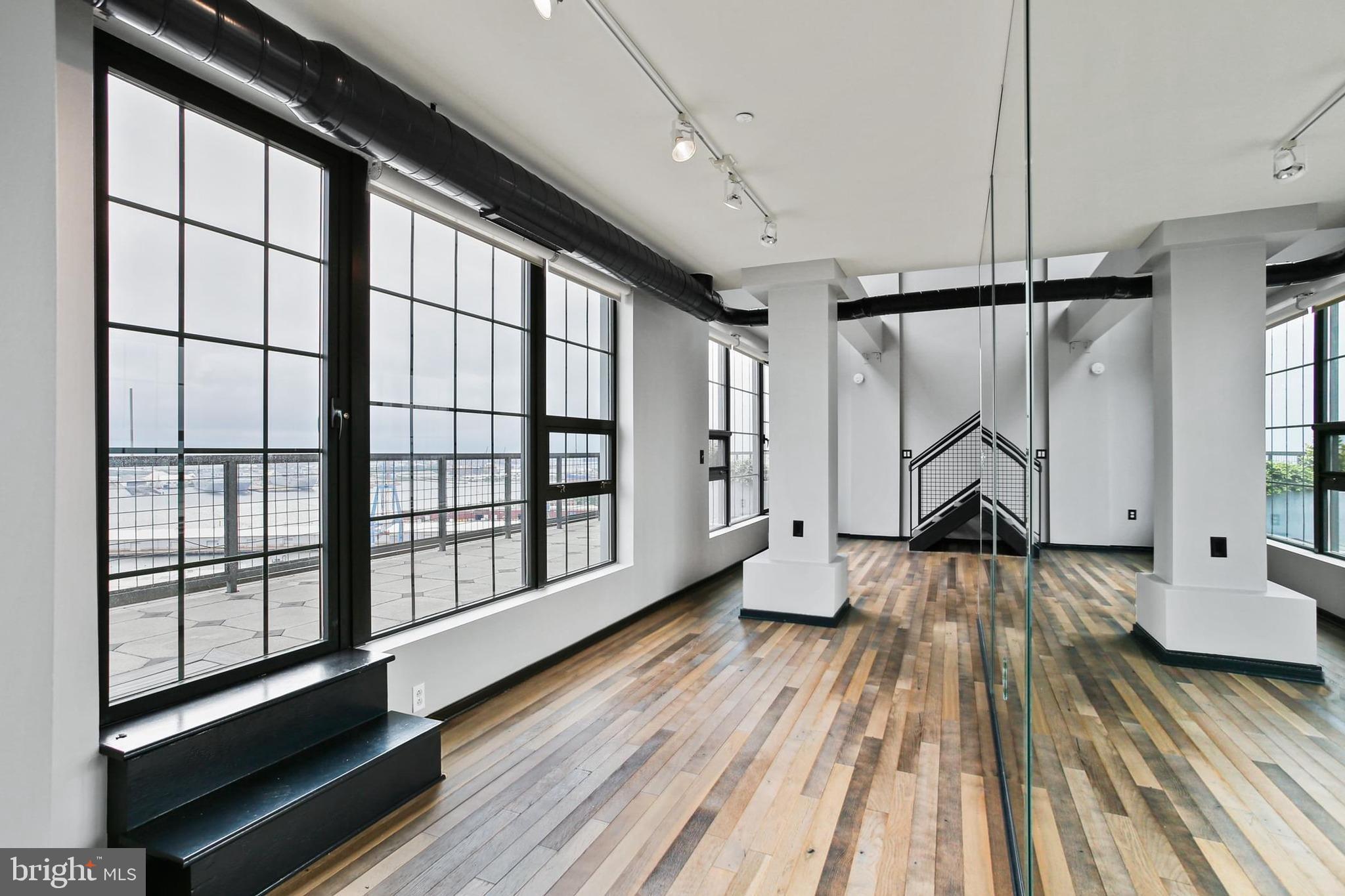 1200 Steuart Street, Unit 1913 Baltimore, MD 21230 - Photo 7 of 39 a view of empty room with wooden floor and fan