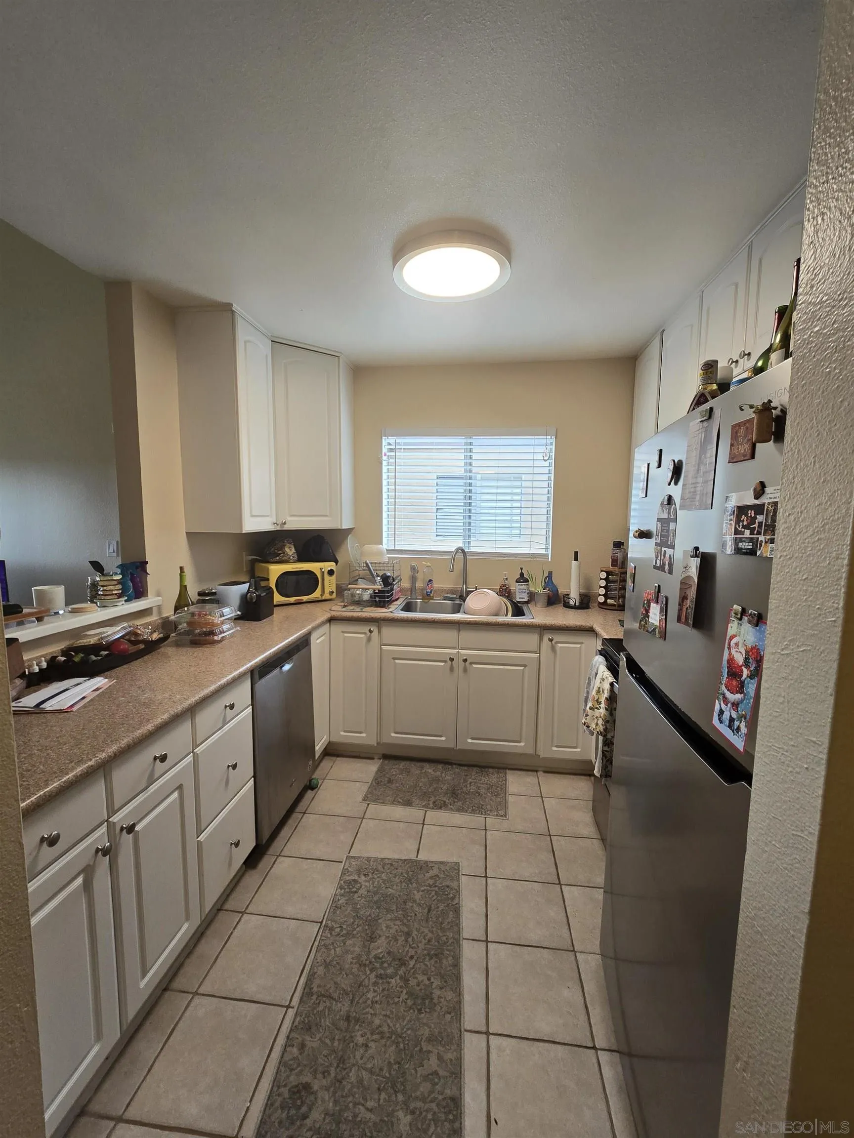 1050 Rock Springs Road, Unit 240 Escondido, CA 92026 - Photo 9 of 21 a large white kitchen with a stove a sink dishwasher and a refrigerator
