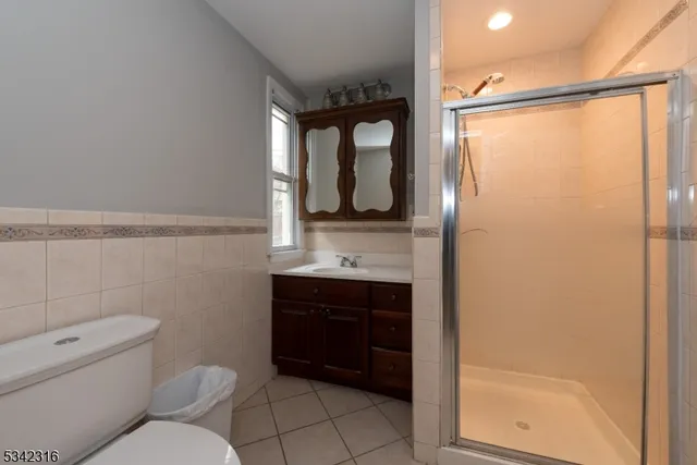 a bathroom with a toilet sink vanity and shower