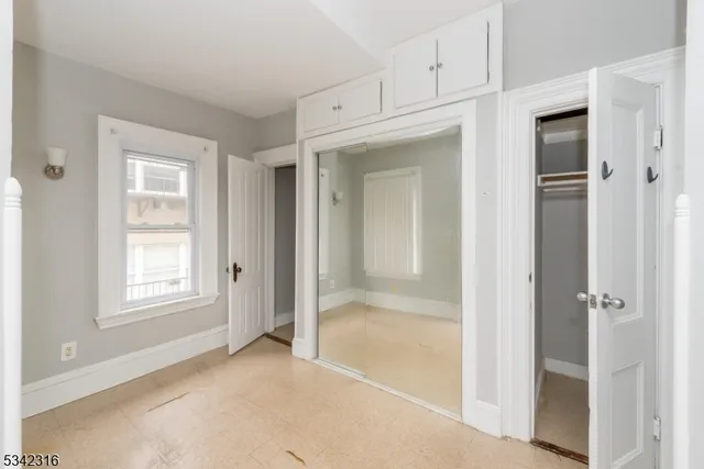 a view of an empty room with window and closet area