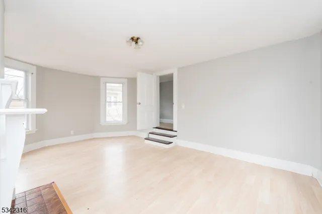 an empty room with windows and closet