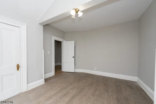 a view of a room with wooden floor and a ceiling fan