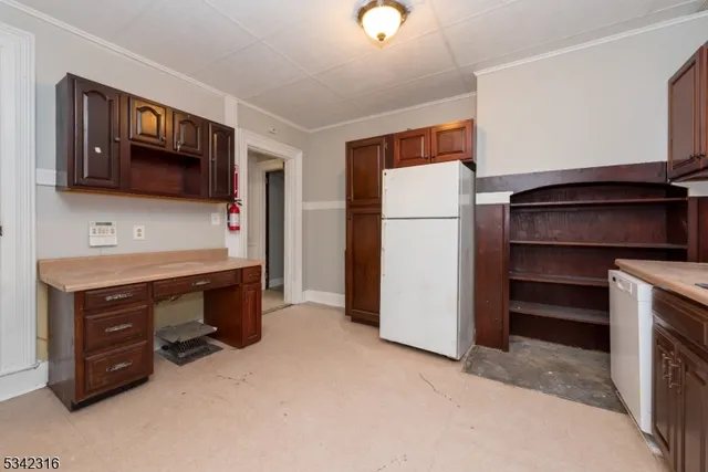 a room with furniture a refrigerator and a dresser