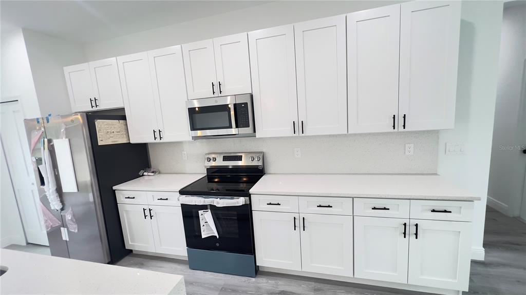16734 Southwest 18th Avenue Road Ocala, FL 34473 - Photo 12 of 36 a kitchen with stainless steel appliances white cabinets and a refrigerator
