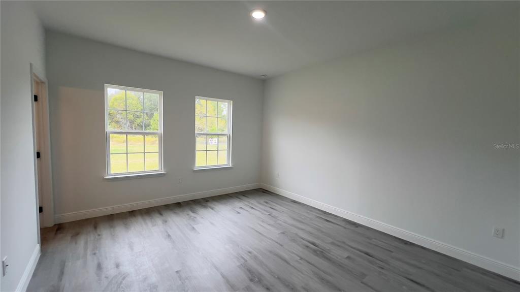 16734 Southwest 18th Avenue Road Ocala, FL 34473 - Photo 14 of 36 an empty room with wooden floor and windows