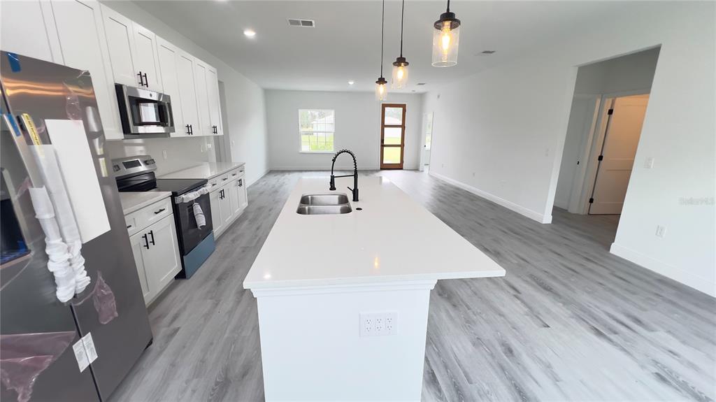 16734 Southwest 18th Avenue Road Ocala, FL 34473 - Photo 8 of 36 a large white kitchen with wooden floor
