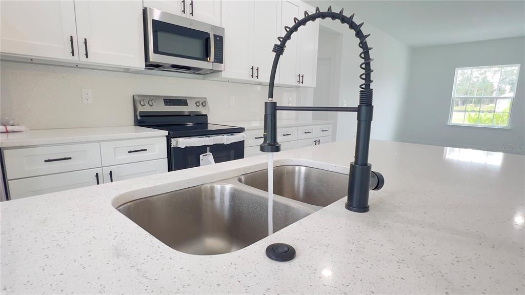 16734 Southwest 18th Avenue Road Ocala, FL 34473 - Photo 9 of 36 a kitchen with stainless steel appliances granite countertop a sink a stove and a granite counter tops