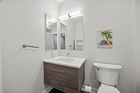 a bathroom with a toilet a sink and mirror