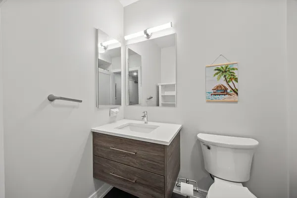 a bathroom with a toilet a sink and mirror