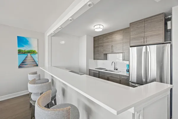 a kitchen with stainless steel appliances a white refrigerator a sink a stove and a refrigerator