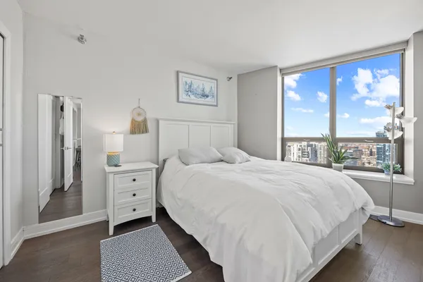 a bedroom with a bed and a large window