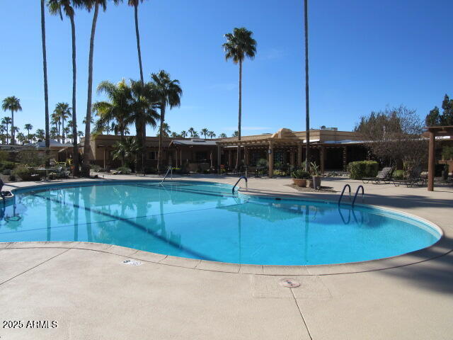 3411 South Camino Seco, Unit 443 Tucson, AZ 85730 - Photo 18 of 20 a view of a swimming pool with a lawn chairs