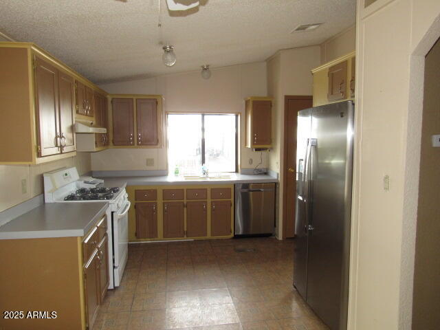 3411 South Camino Seco, Unit 443 Tucson, AZ 85730 - Photo 7 of 20 a kitchen with a sink stove and refrigerator