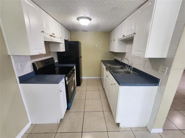 a kitchen with stainless steel appliances a stove a sink and a refrigerator
