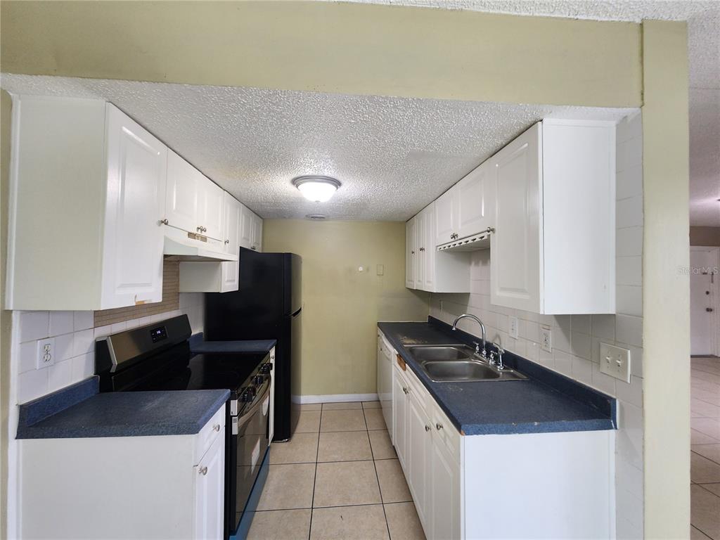 5228 Curry Ford Road, Unit 320 Orlando, FL 32812 - Photo 4 of 19 a kitchen with a sink a stove and a refrigerator