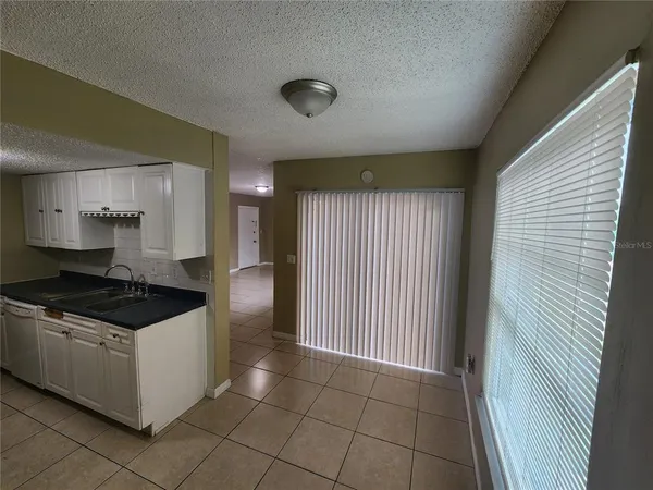 a kitchen with granite countertop a stove top oven and cabinets
