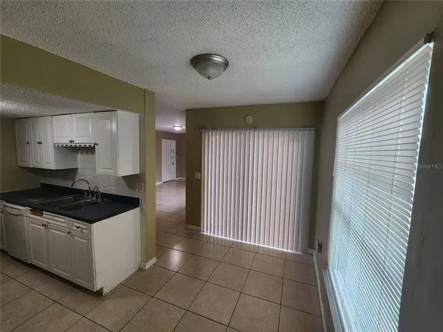a kitchen with granite countertop a stove top oven and cabinets