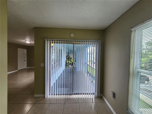 a view of a hallway with wooden floor and a bathroom