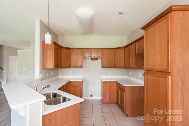 a kitchen with a sink a refrigerator and cabinets