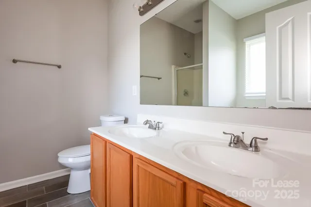 a bathroom with a granite countertop sink a toilet and a mirror