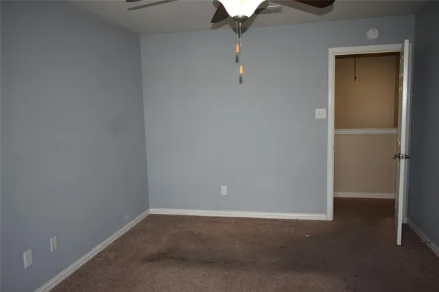 en empty room with closet and chandelier fan