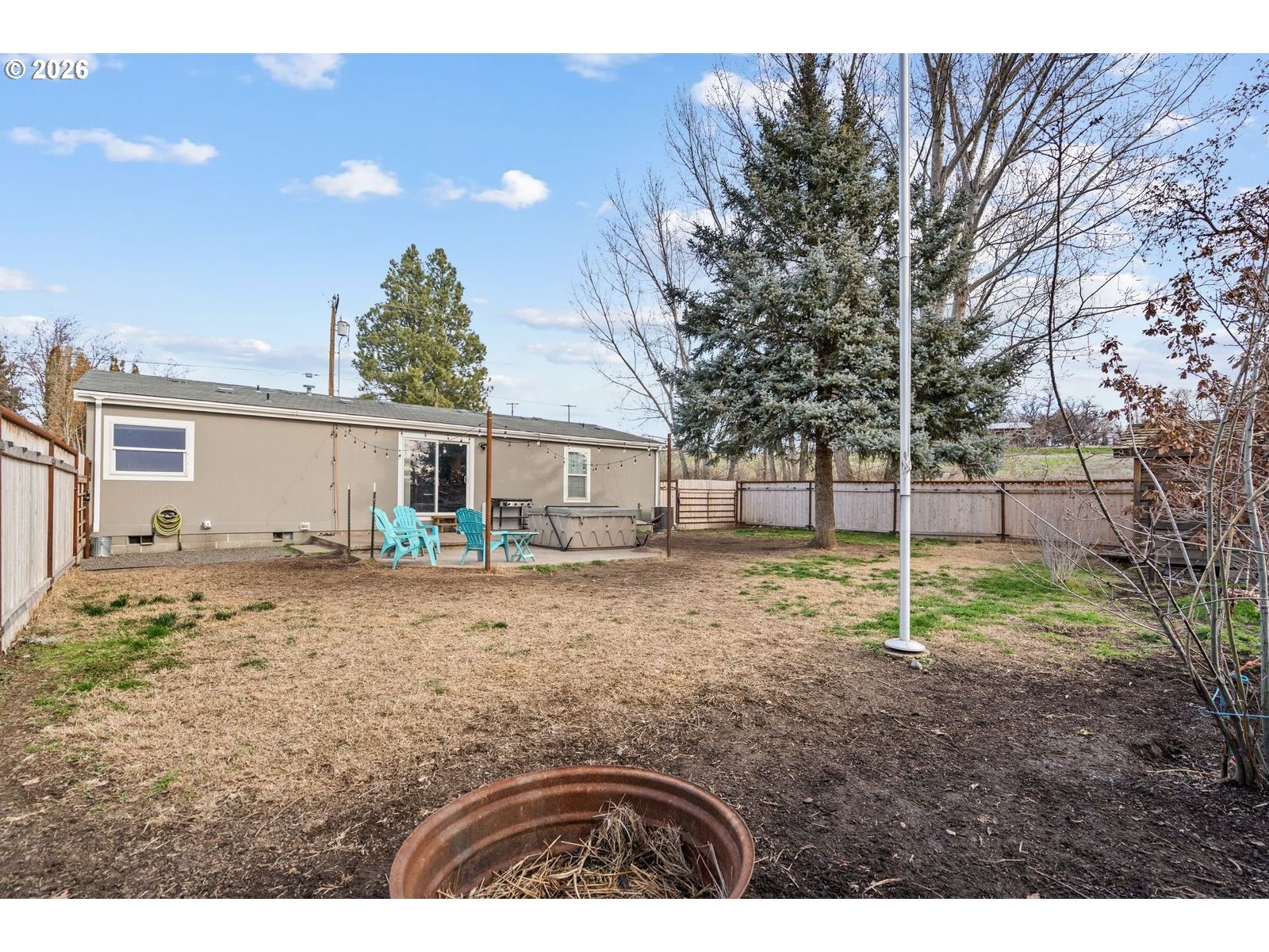 910 East College Echo, OR 97826 - Photo 18 of 23 a backyard of a house with wooden fence and large trees