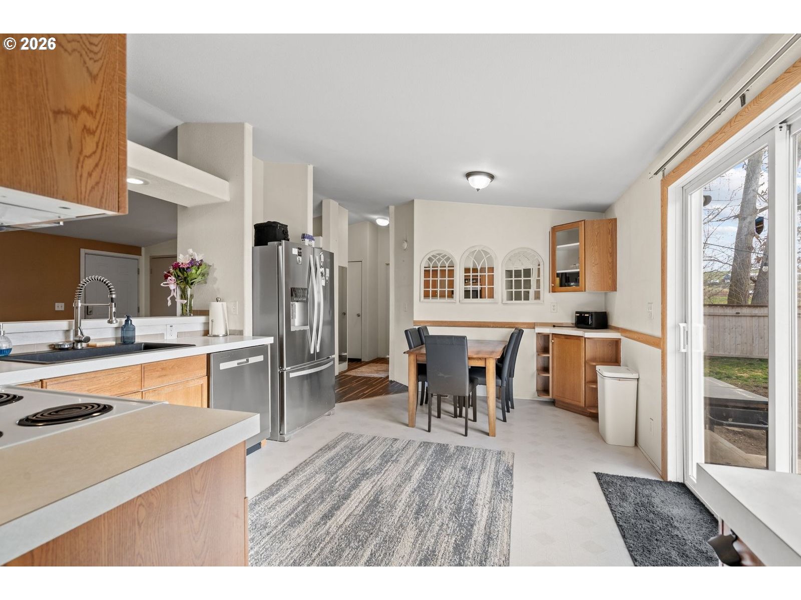 910 East College Echo, OR 97826 - Photo 8 of 23 a open kitchen with stainless steel appliances granite countertop a refrigerator a stove a sink a dining table and chairs with wooden floor