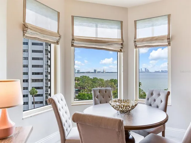 a patio with table and chairs and potted plants