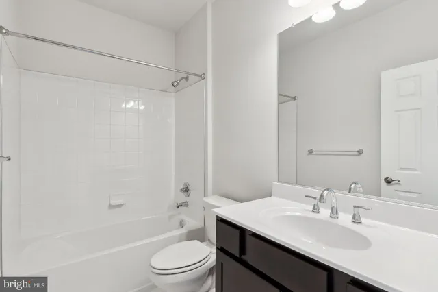 a bathroom with a sink a toilet a mirror and shower