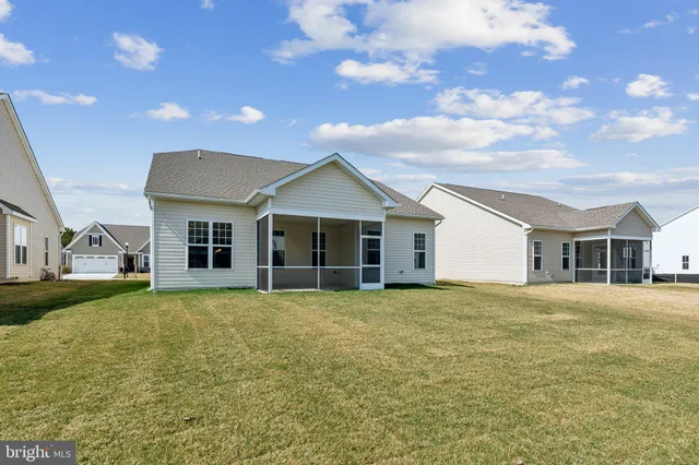 a view of a yard in front of a house with a large tree