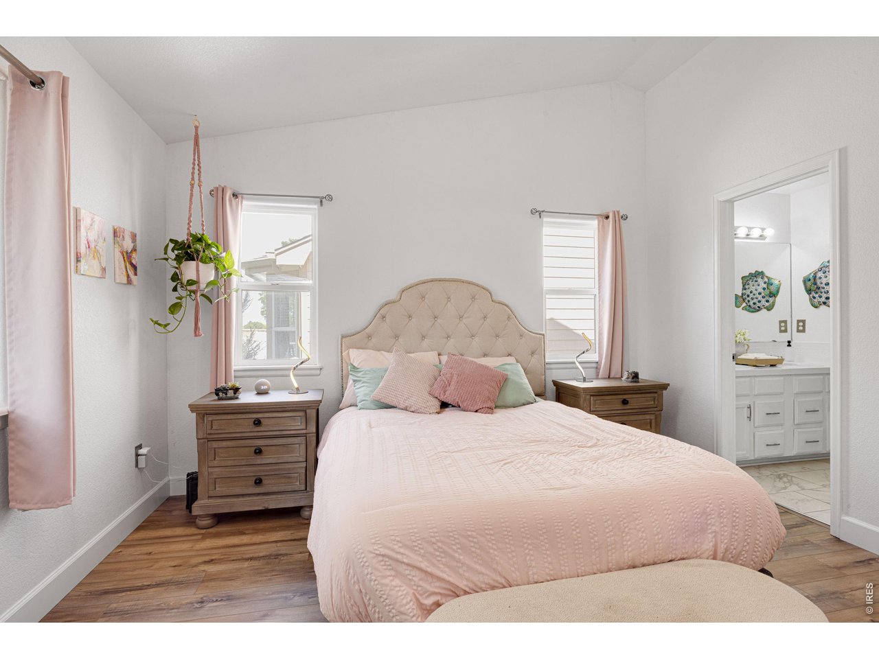148 Beacon Way Windsor, CO 80550 - Photo 18 of 36 Spacious primary bedroom featuring vaulted ceilings, large windows, and private ensuite bathroom.