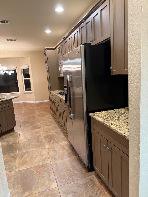 235 Red Poppy Trail Georgetown, TX 78633 - Photo 5 of 21 a kitchen with granite countertop a refrigerator and a stove