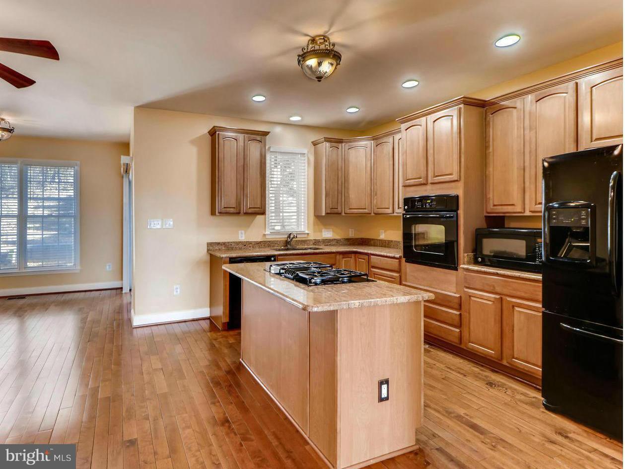 4701 Falls Road Baltimore, MD 21209 - Photo 1 of 28 a kitchen with stainless steel appliances a stove a refrigerator a sink and white cabinets with wooden floor