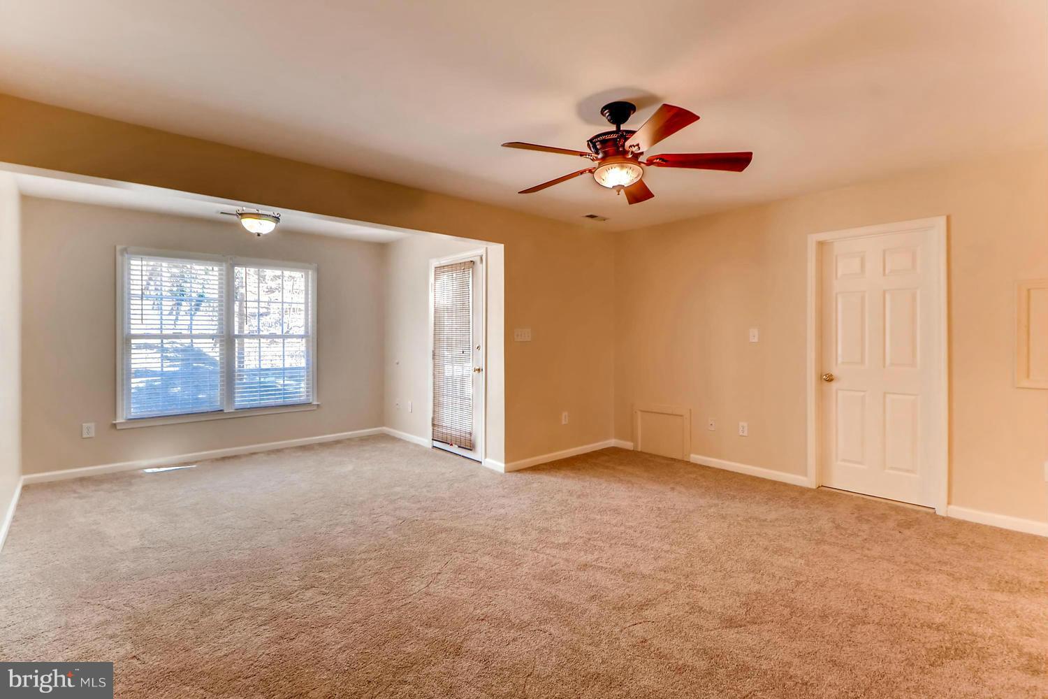 4701 Falls Road Baltimore, MD 21209 - Photo 13 of 28 an empty room with windows and fan chandelier