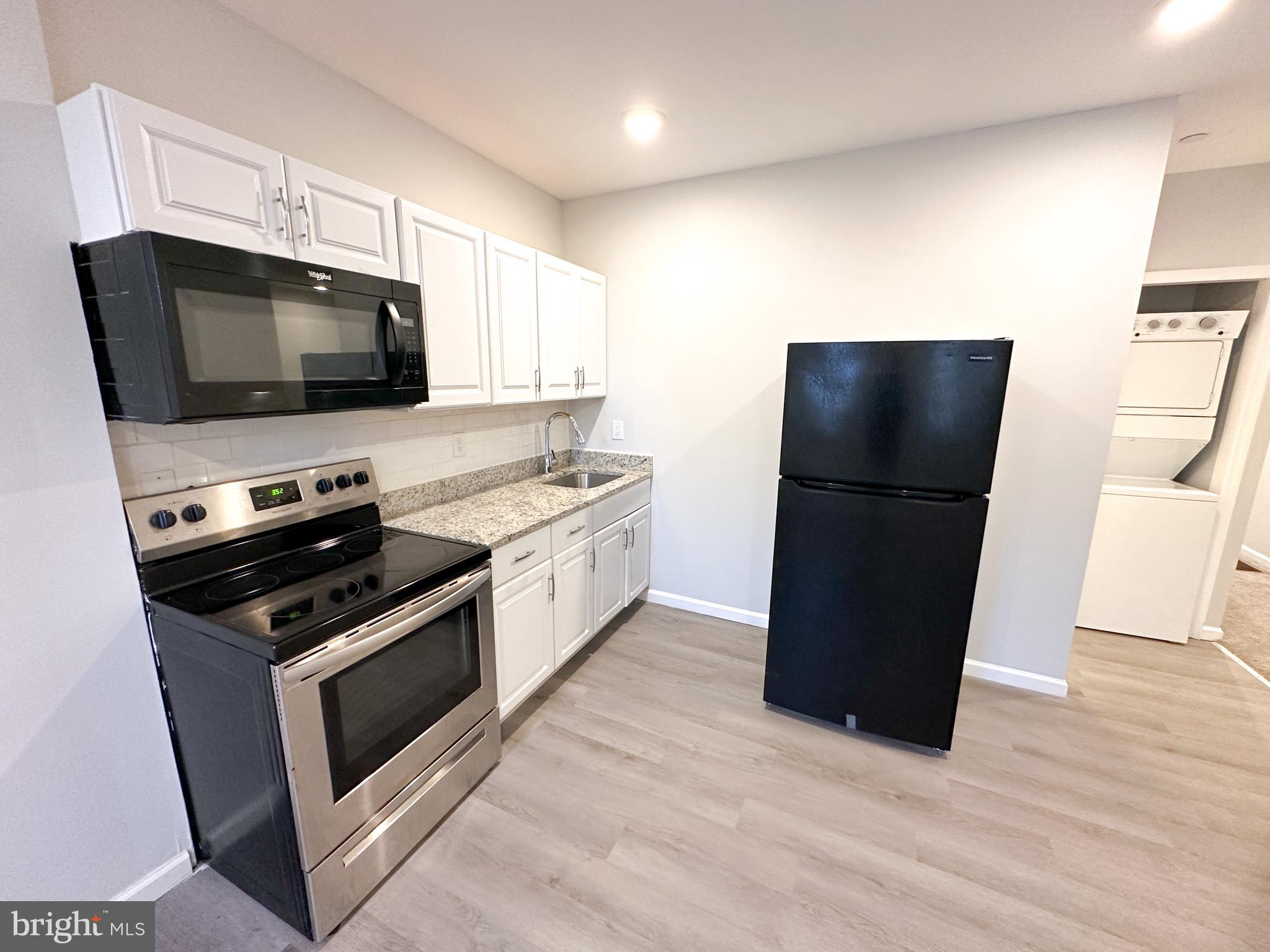 2404 West Thompson Street, Unit A Philadelphia, PA 19121 - Photo 1 of 13 a kitchen with a refrigerator stove and microwave