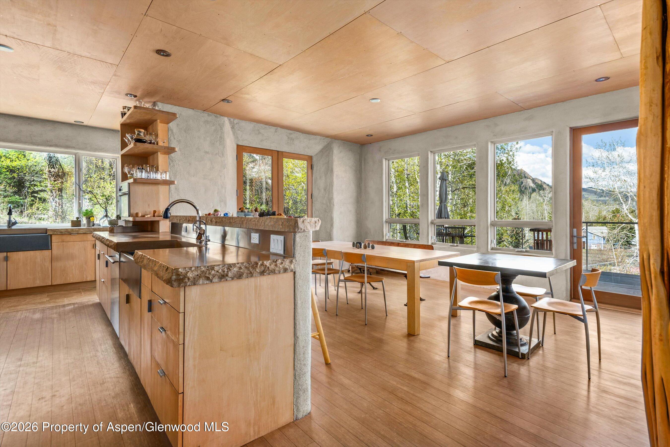 515 Park Circle Aspen, CO 81611 - Photo 9 of 34 a dining hall with stainless steel appliances granite countertop a stove top oven a dining table and chairs with wooden floor