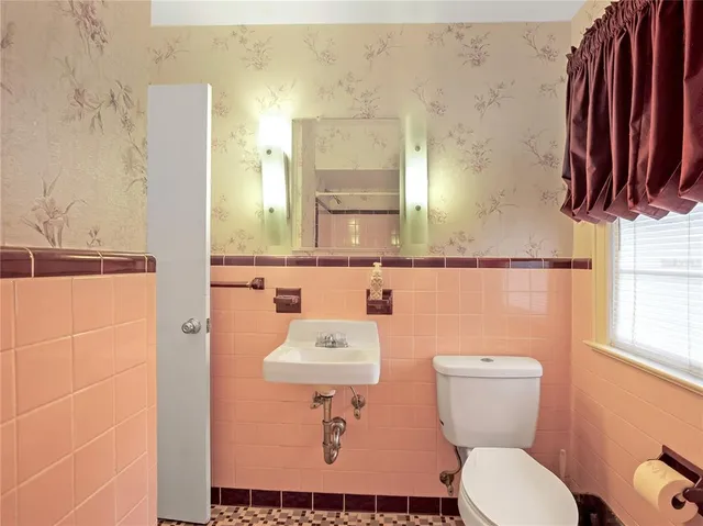 a bathroom with a toilet a sink and a mirror