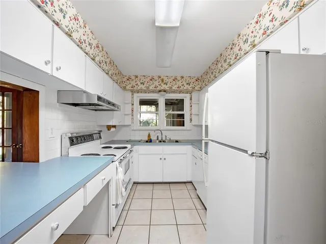 a kitchen with a sink a stove cabinets and stainless steel appliances