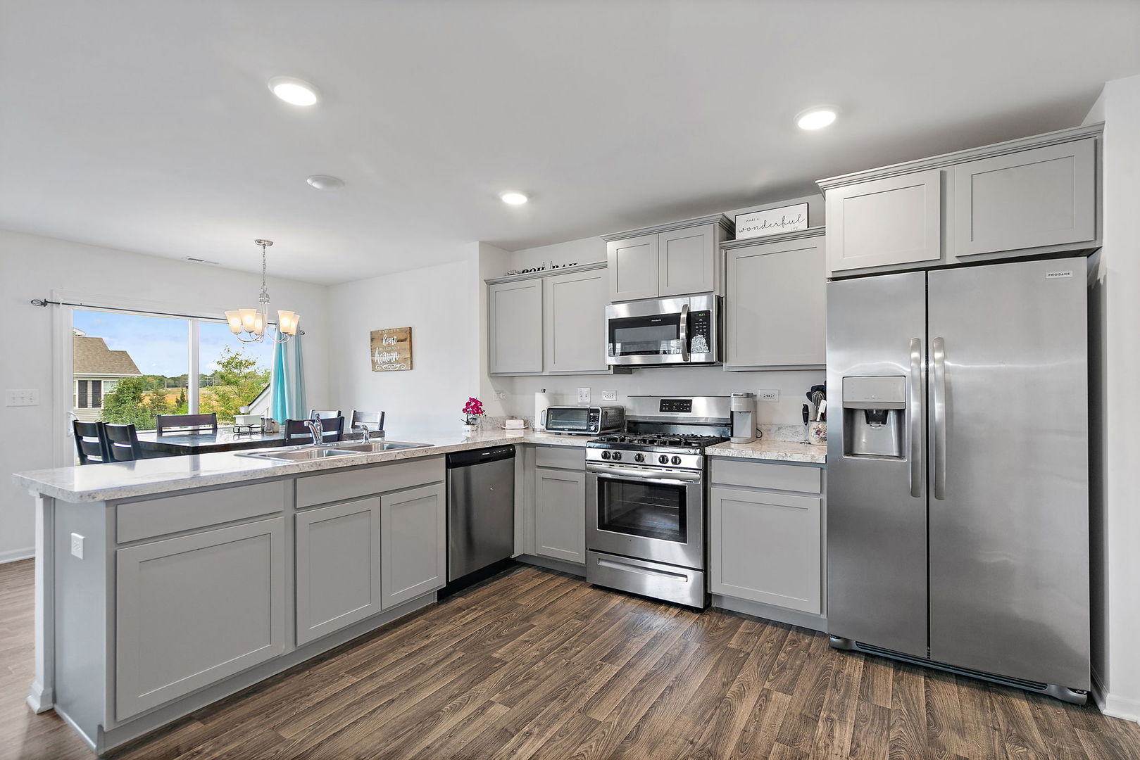 2360 Upland Road, Unit 2267 Hampshire, IL 60140 - Photo 5 of 26 a kitchen with a refrigerator a sink dishwasher a stove and white cabinets with wooden floor