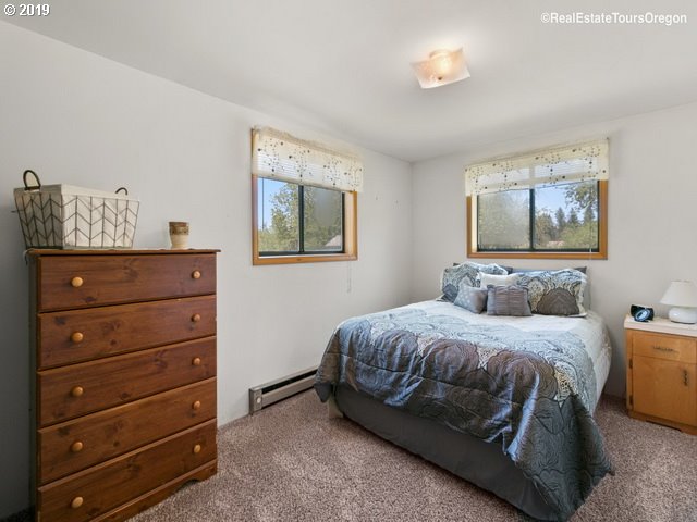 24311 South Larkin Road Beavercreek, OR 97004 - Photo 13 of 31 a bedroom with a bed and a painting on the wall