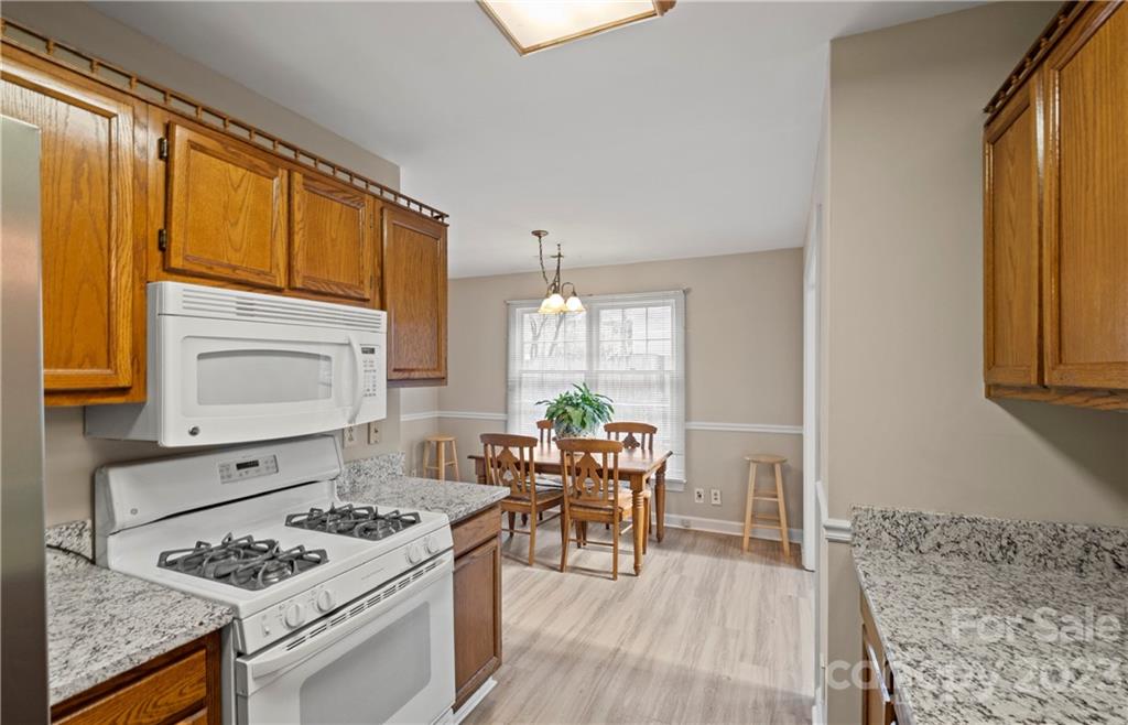 13514 O O'Malley Drive Matthews, NC 28105 - Photo 9 of 20 a living room with furniture a dining table and a stove with wooden floor