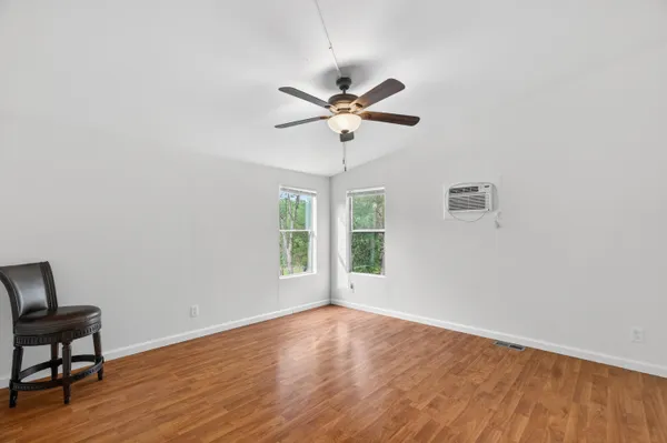 an empty room with wooden floor and a window